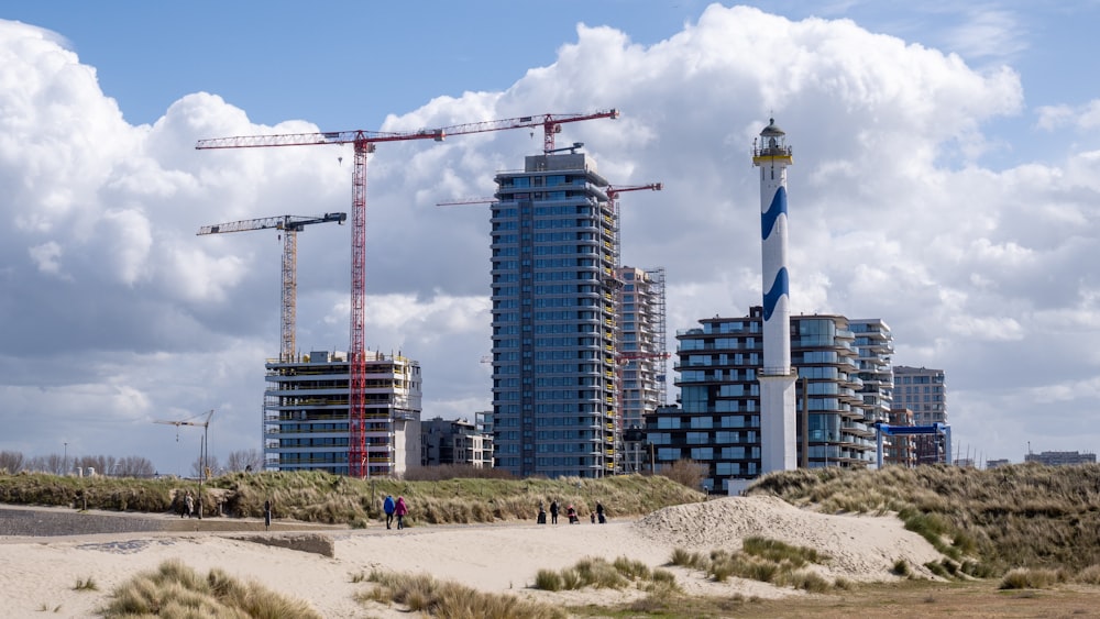 Un gruppo di persone che camminano su una spiaggia accanto a edifici alti