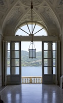 an open door leading to a balcony with a view of a lake
