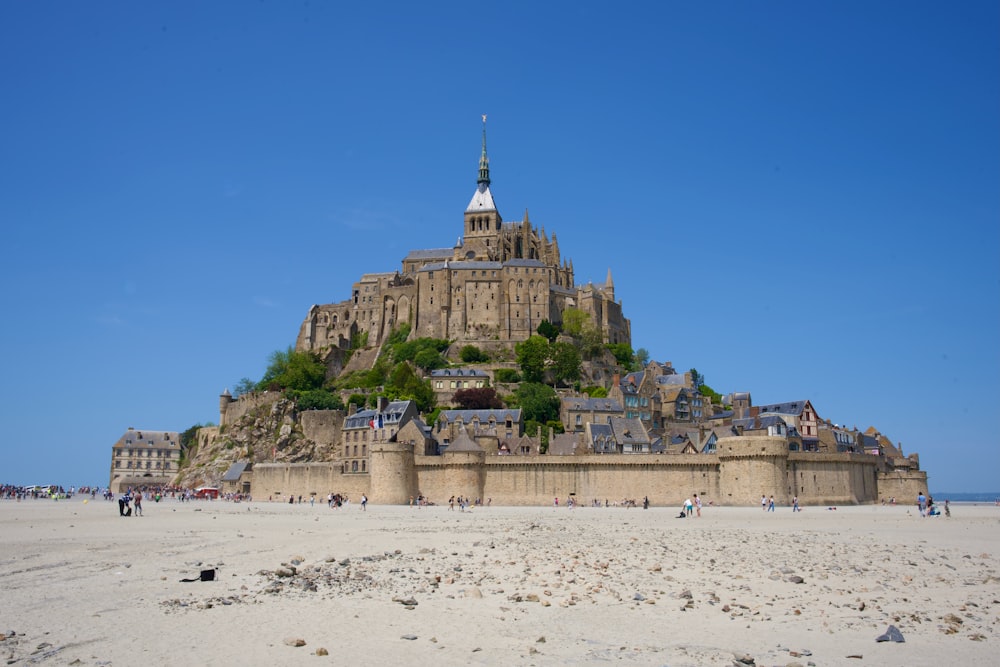 Un castello molto grande seduto sulla cima di una spiaggia sabbiosa