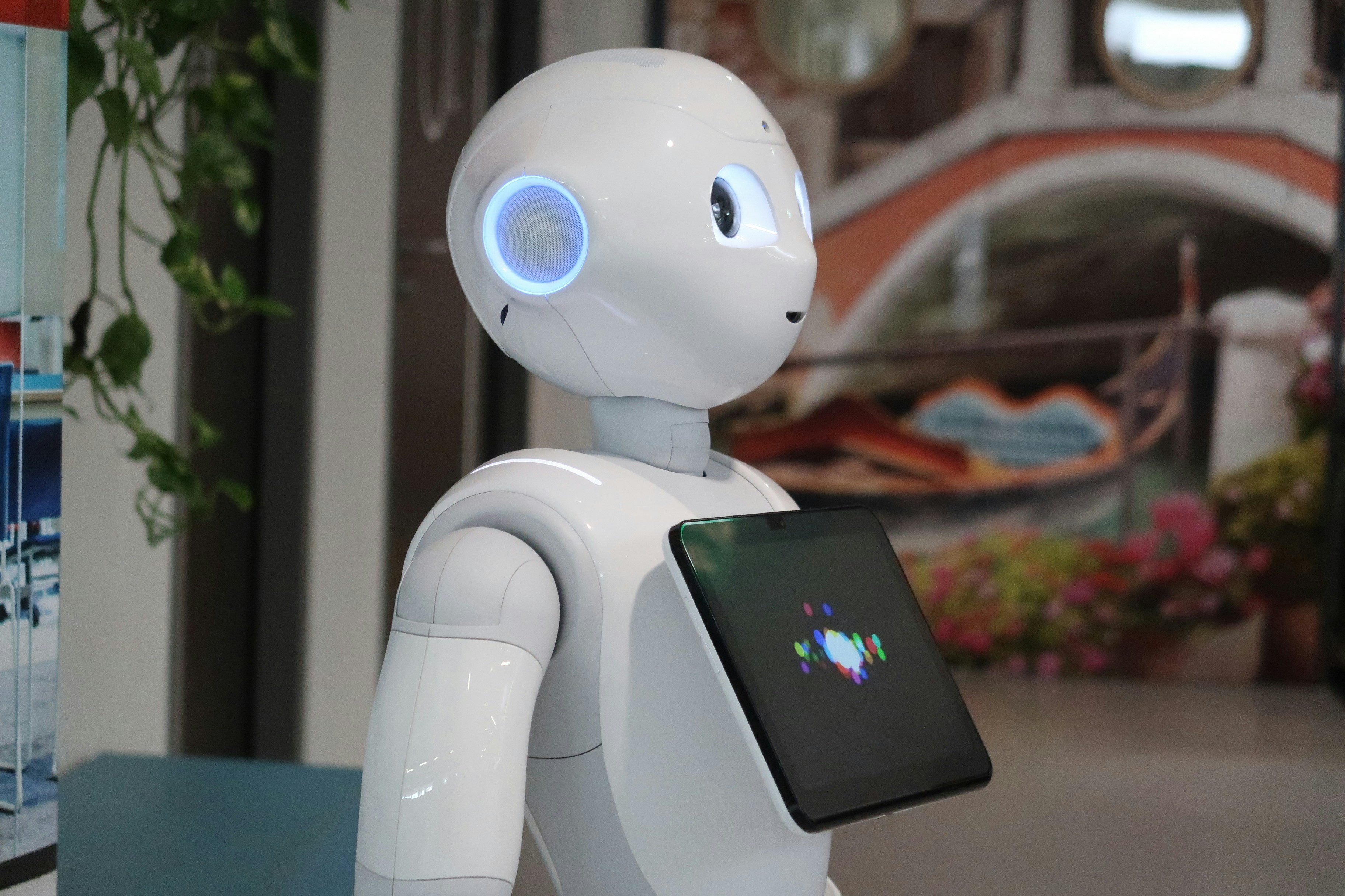 Branimo white robot holding a tablet in its hand, showcasing technology and innovation