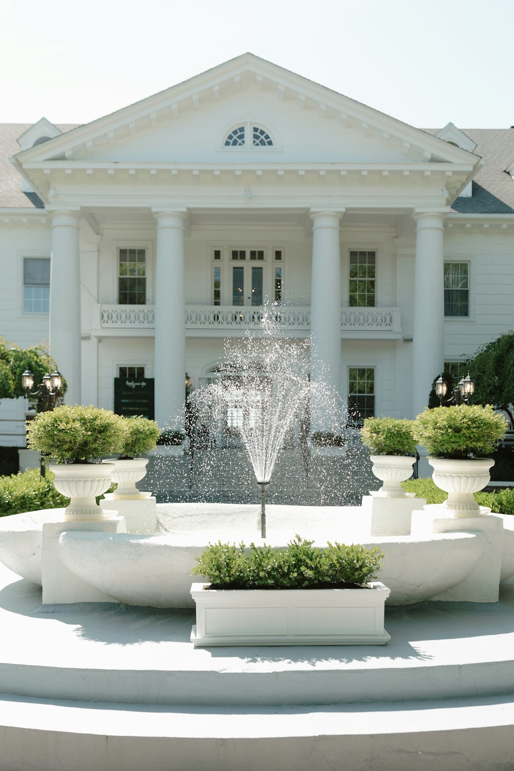 a large white building with a fountain in front of it