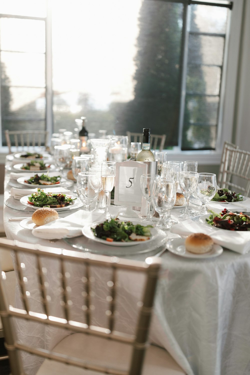 a table set with plates of food and wine glasses