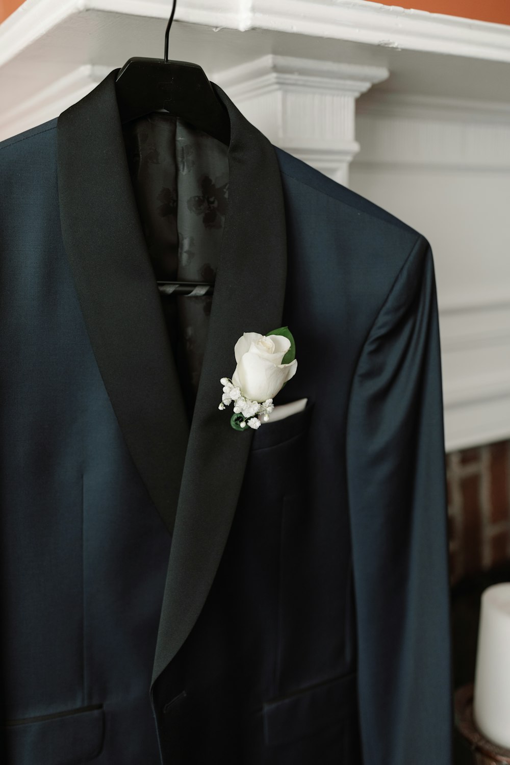 un costume noir avec une fleur blanche dessus