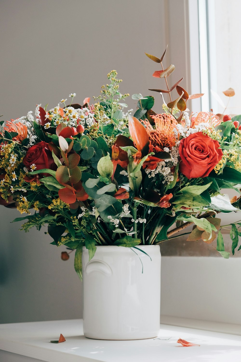 Un ramo de flores en un jarrón blanco