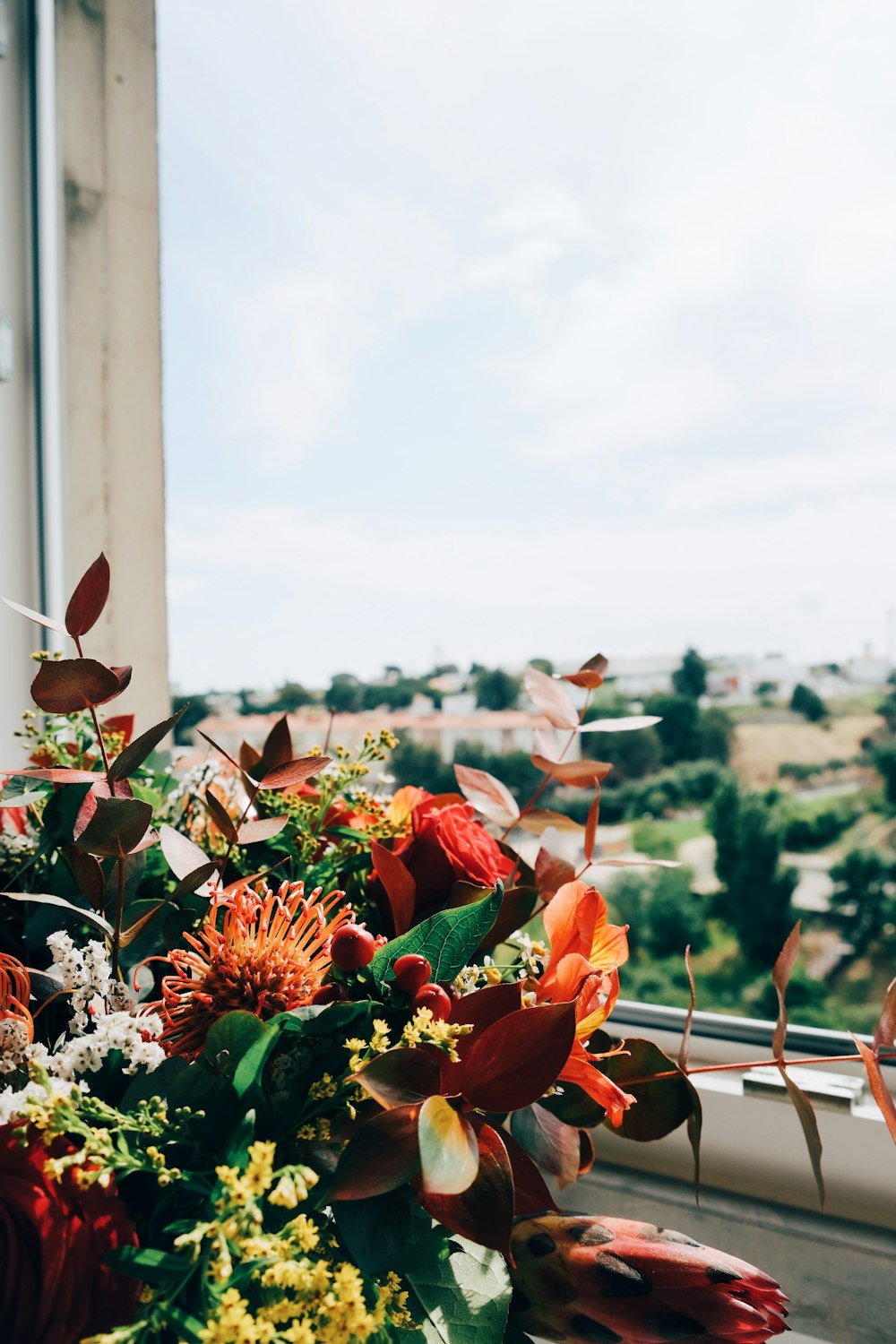 a bouquet of flowers sitting on top of a window sill