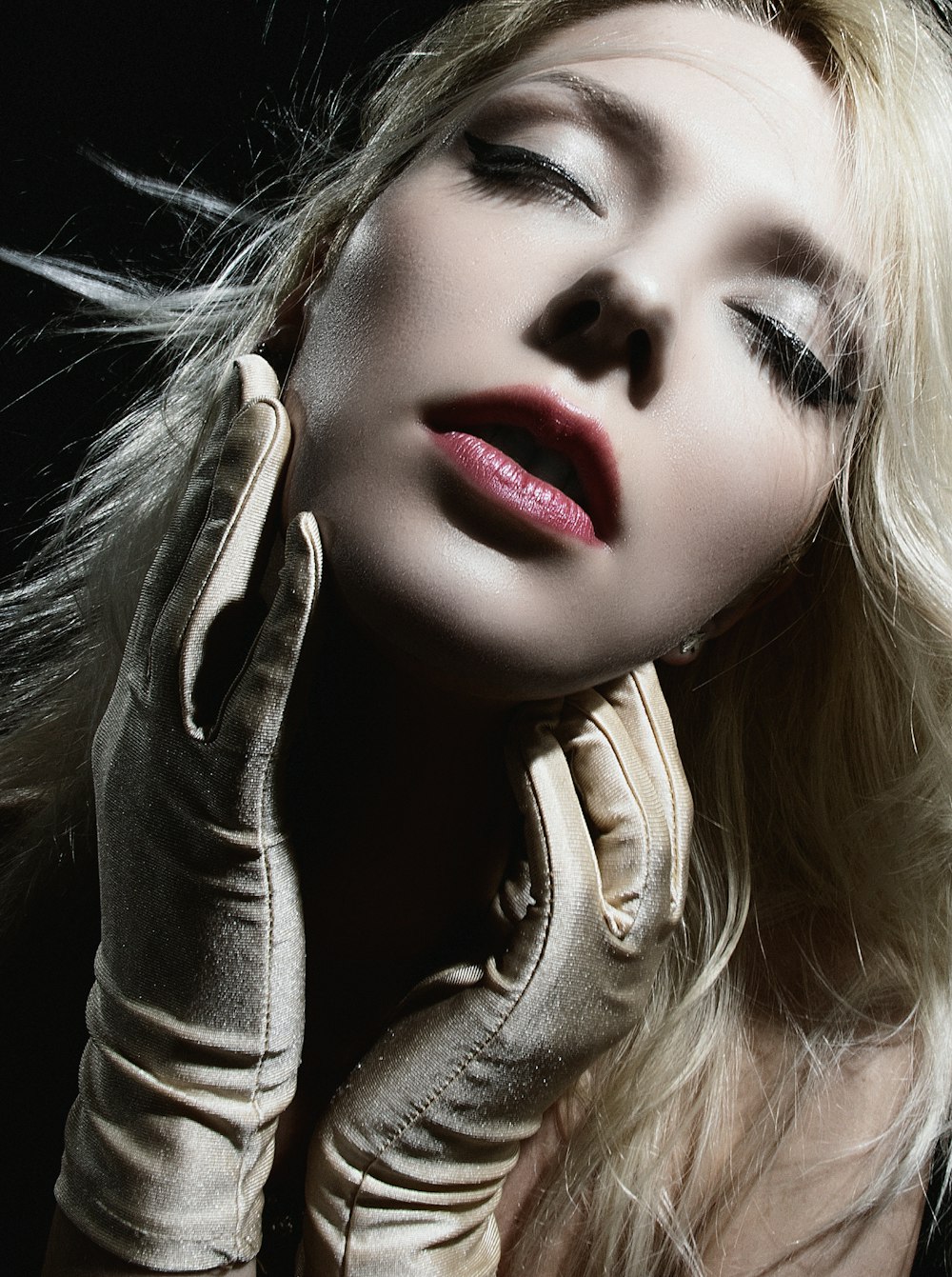 a woman with long blonde hair wearing gloves