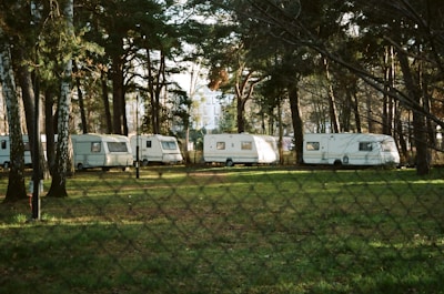 Row of portable cabins lined up on a grassy field under soft sunlight.