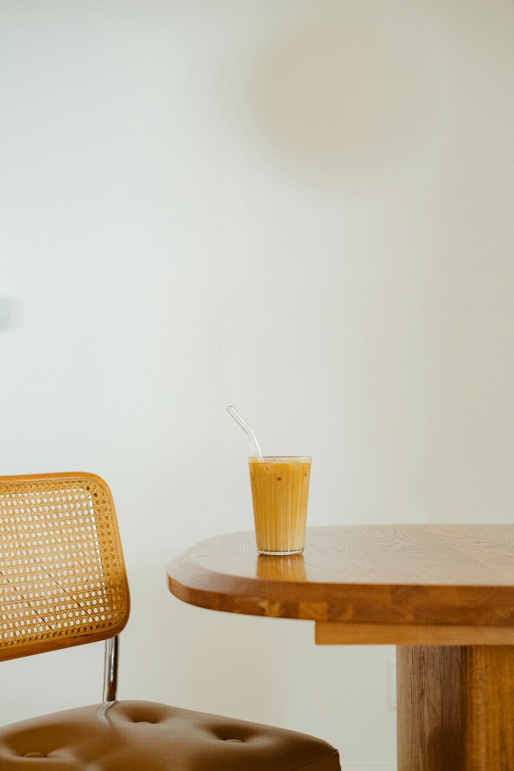 a glass of orange juice sitting on top of a wooden table