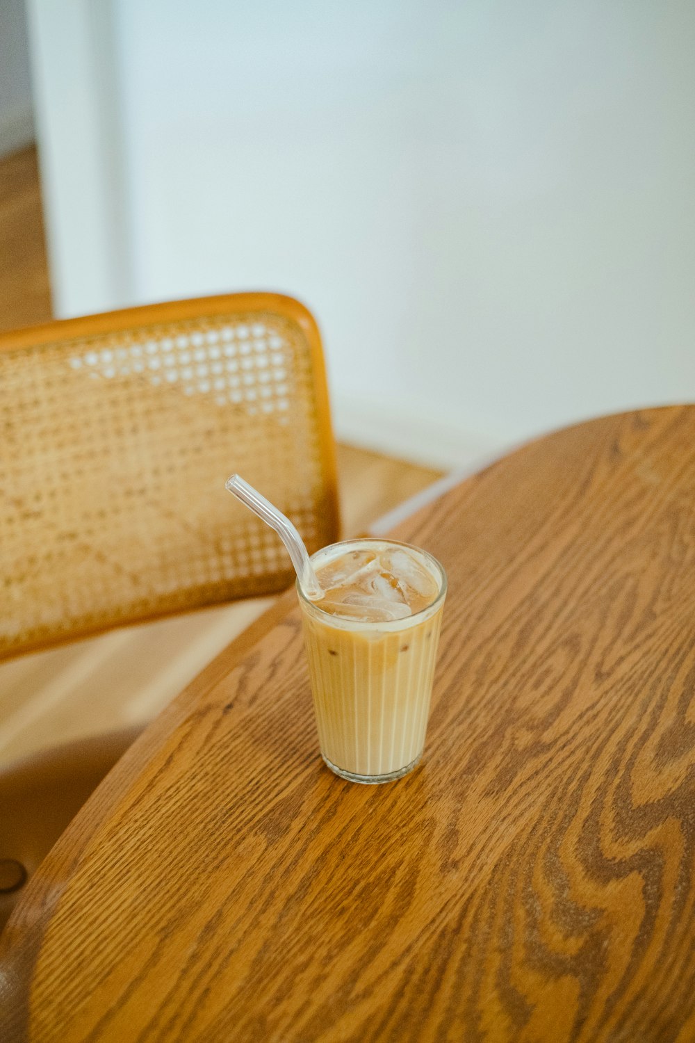 a wooden table topped with a cup filled with liquid