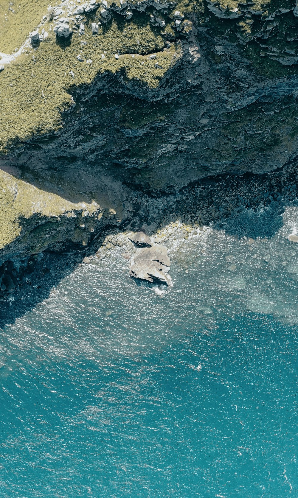 an aerial view of a body of water near a cliff