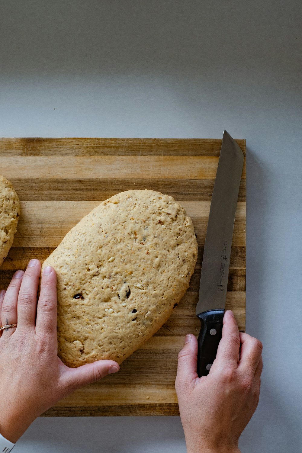 a person cutting a heart shaped cookie on a cutting board