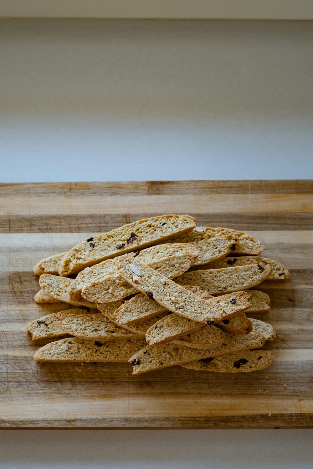 a pile of crackers sitting on top of a wooden cutting board