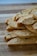 A stack of sliced biscotti placed on a wooden cutting board. The biscotti have a golden-brown color with visible nuts and dried fruit embedded within. The texture appears crunchy and crumbly.