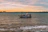 Fishing boat cutting through calm sea waters near Shengjin at sunrise