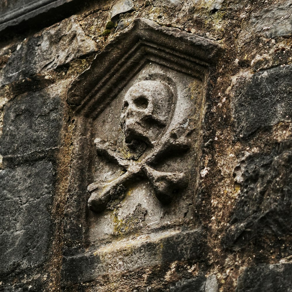 a skull and crossbones carved into a stone wall