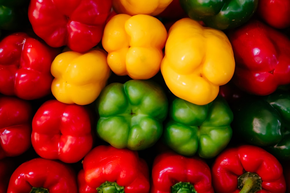 a pile of red, green and yellow peppers