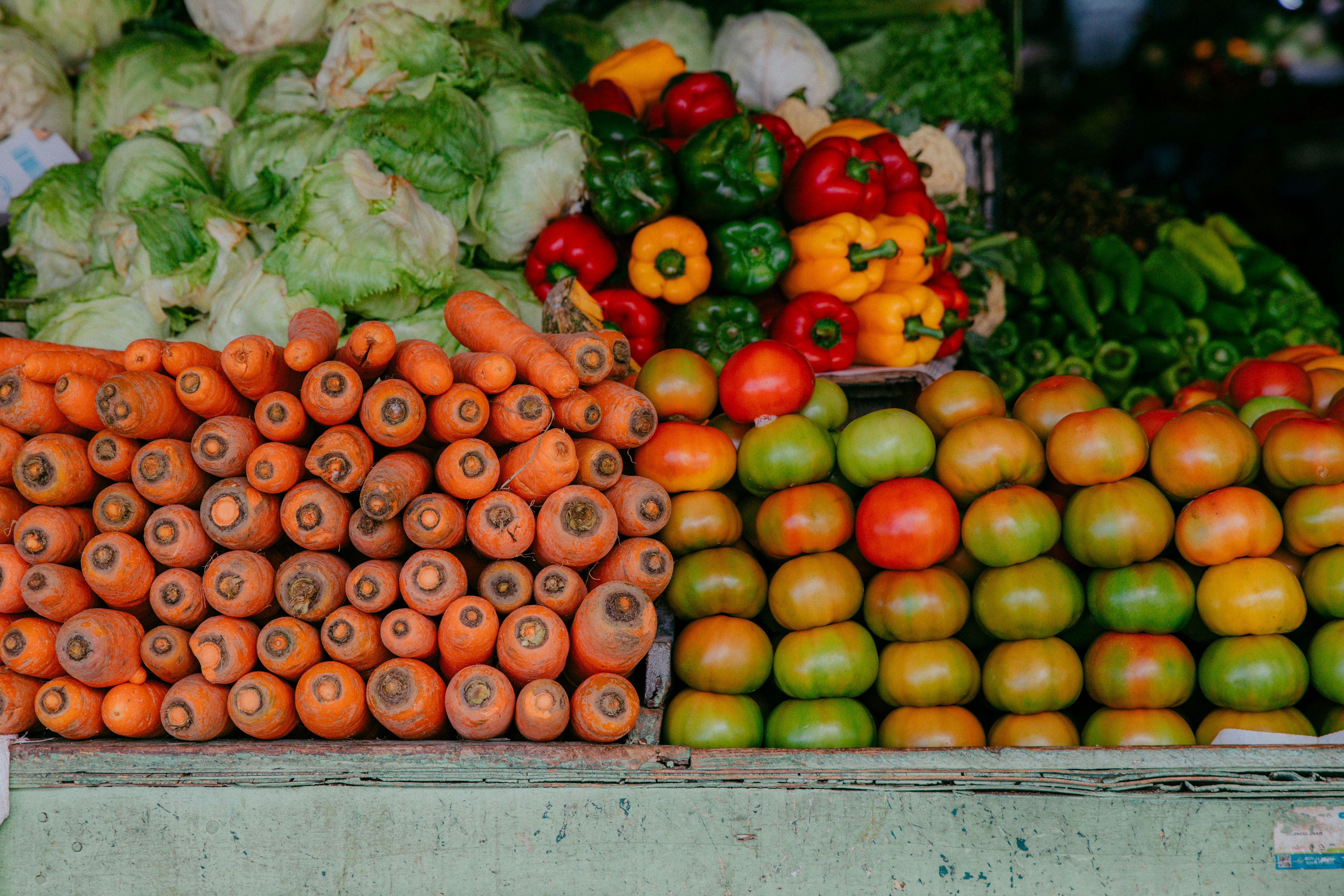 A bright kitchen counter filled with fresh June produce like strawberries and snap peas next to a smartphone showing the EasyHome app.