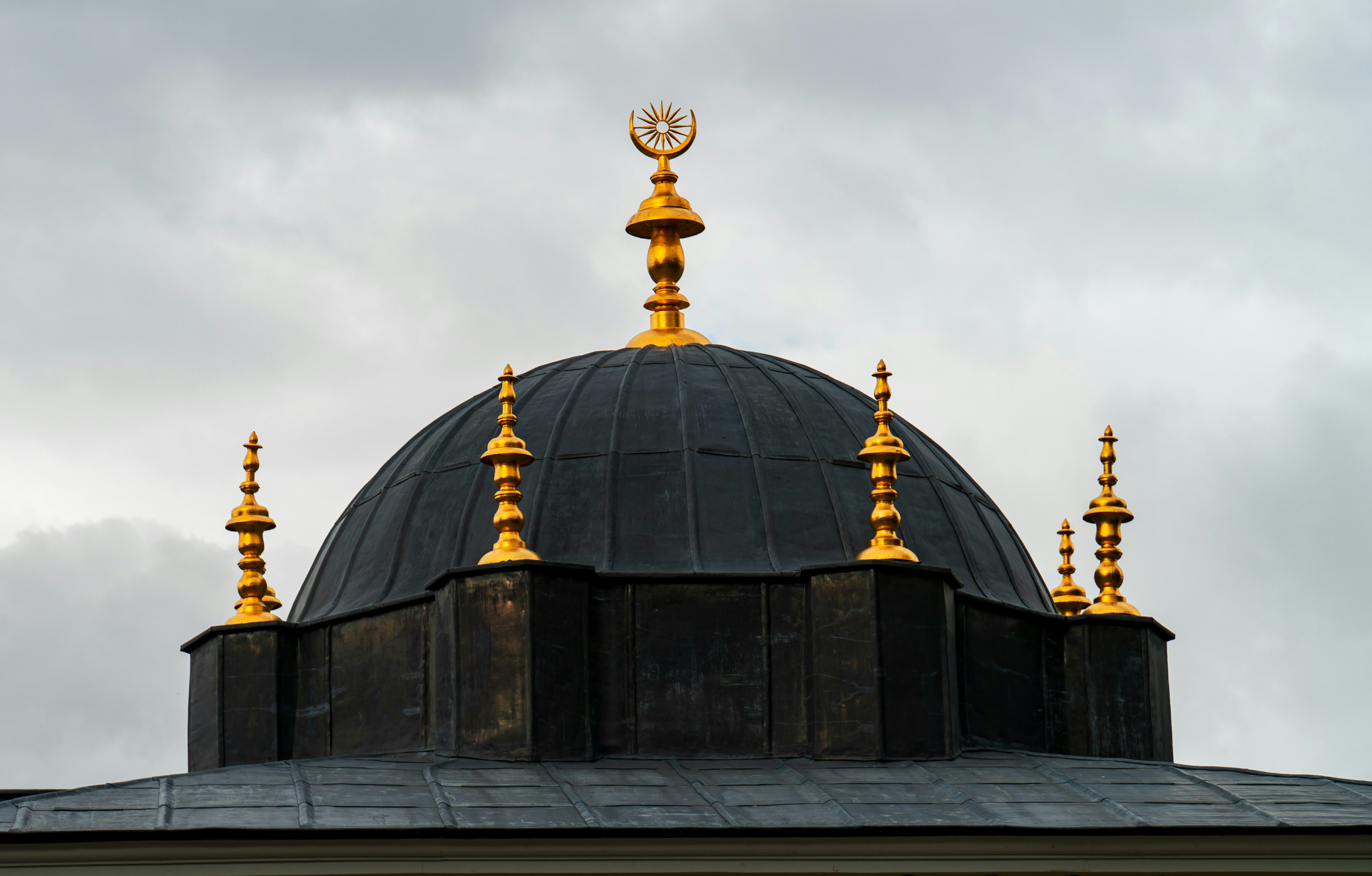 Una cúpula negra y dorada en la parte superior de un edificio