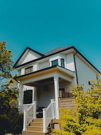 a white house with a porch and stairs