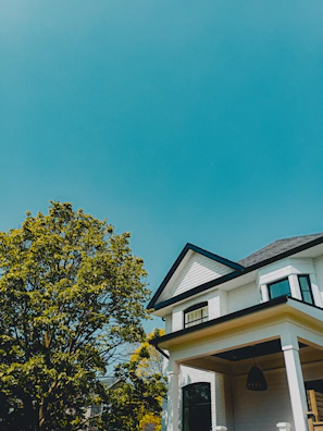 Freshly painted exterior with crisp white trim and deep blue siding under a clear sky.