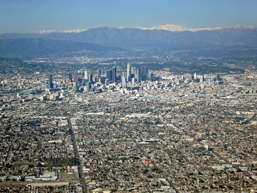 an aerial view of a city with mountains in the background