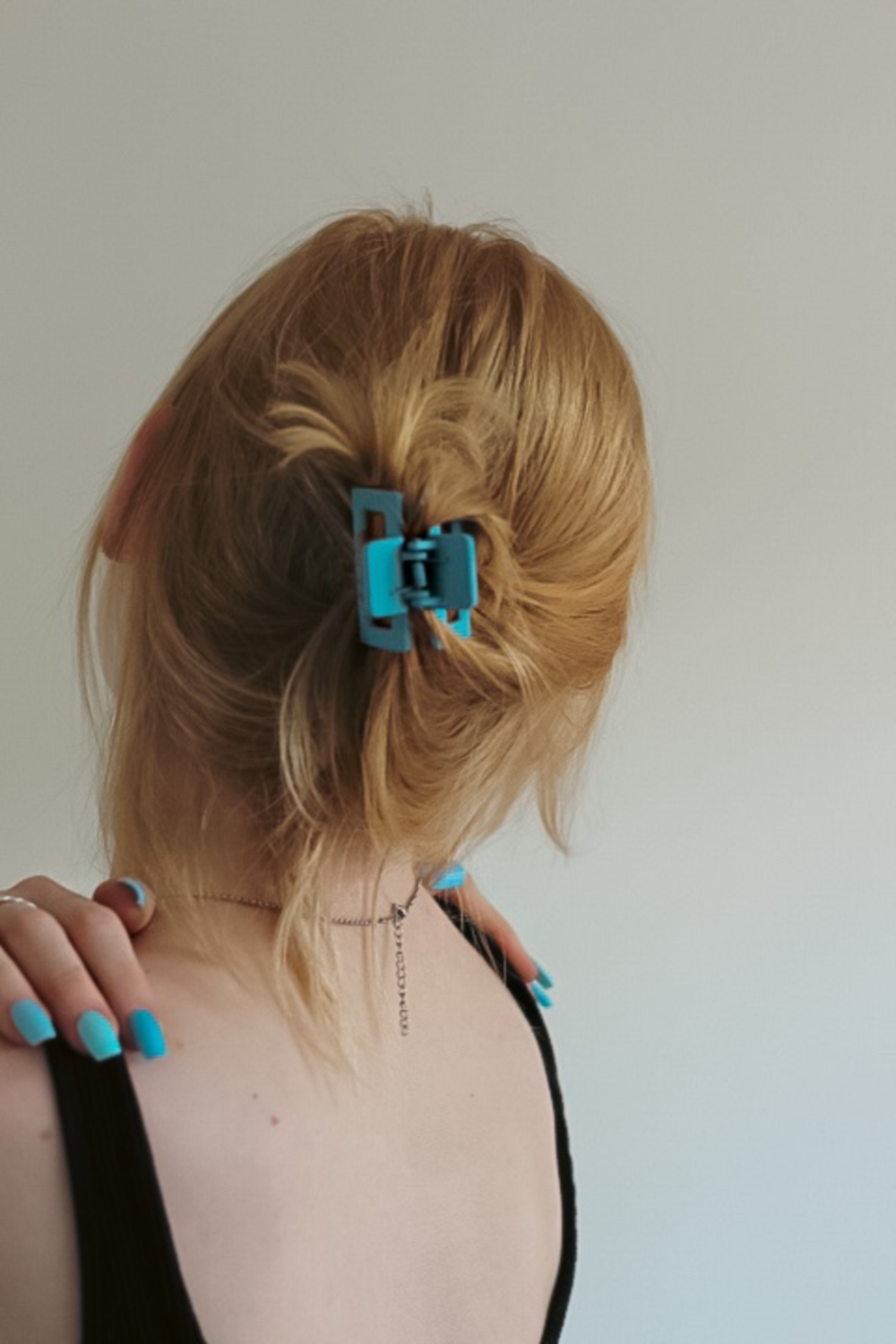 a woman with blue nails and a black top