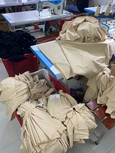 A cozy studio corner with sewing machines and purple mango fabric swatches laid out.