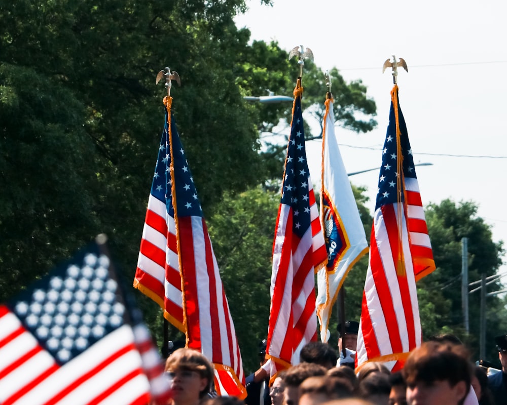 a group of people walking down a street holding american flags