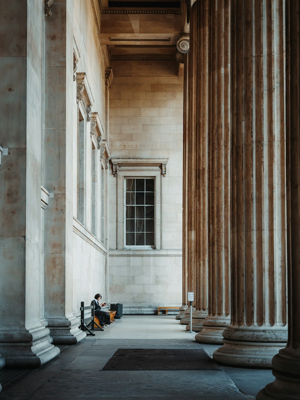 a person sitting on a bench in a large building