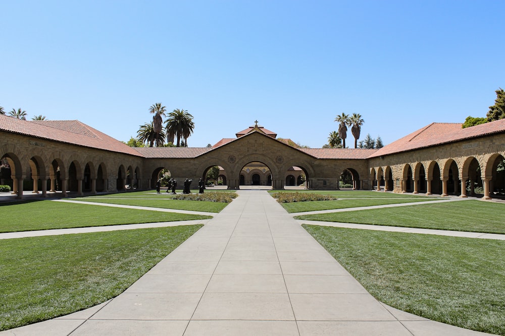 a walkway leading to a building with arches