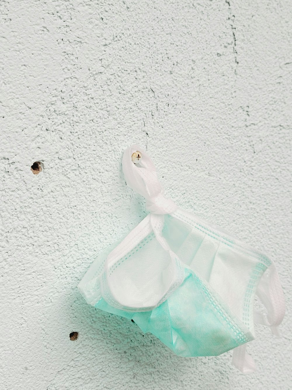 a bag hanging on a wall with a hole in it