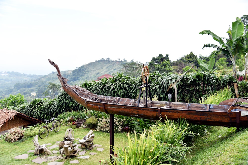 a long boat sitting on top of a lush green hillside