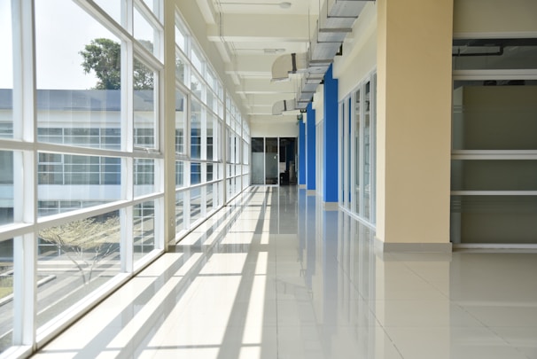 a long hallway with blue and white doors and windows