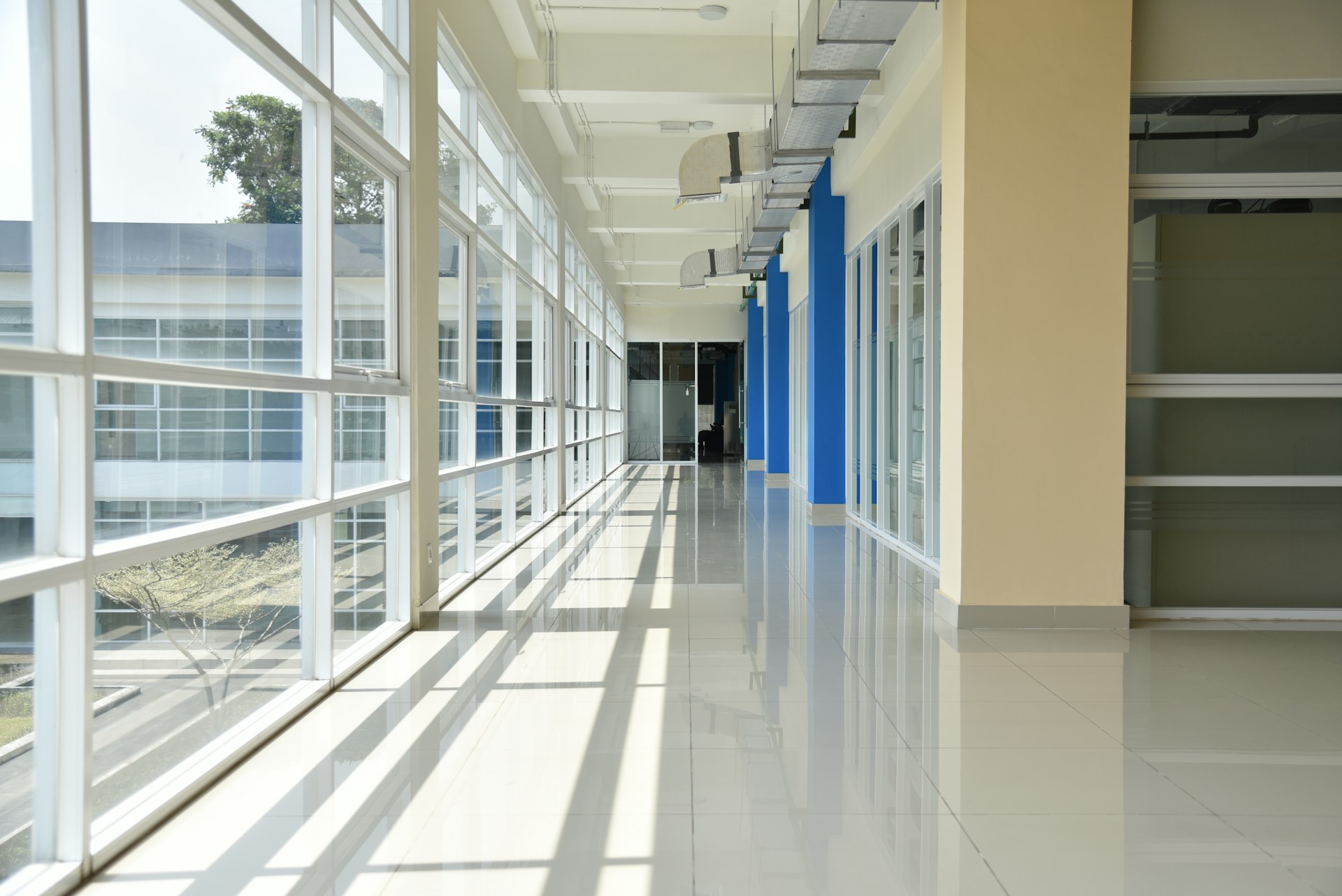 a long hallway with blue and white doors and windows