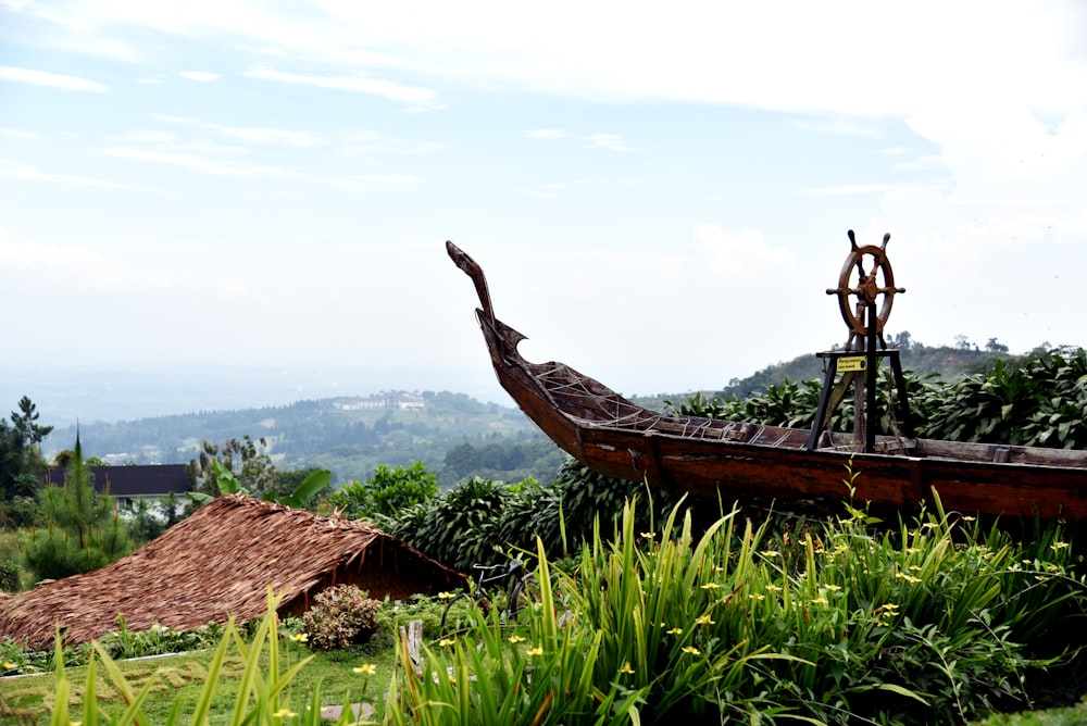 a boat sitting on top of a lush green hillside