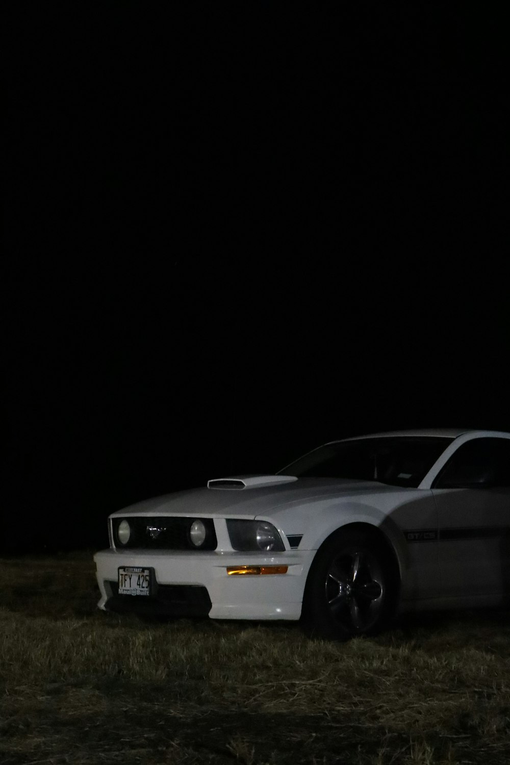 a white car parked in a field at night