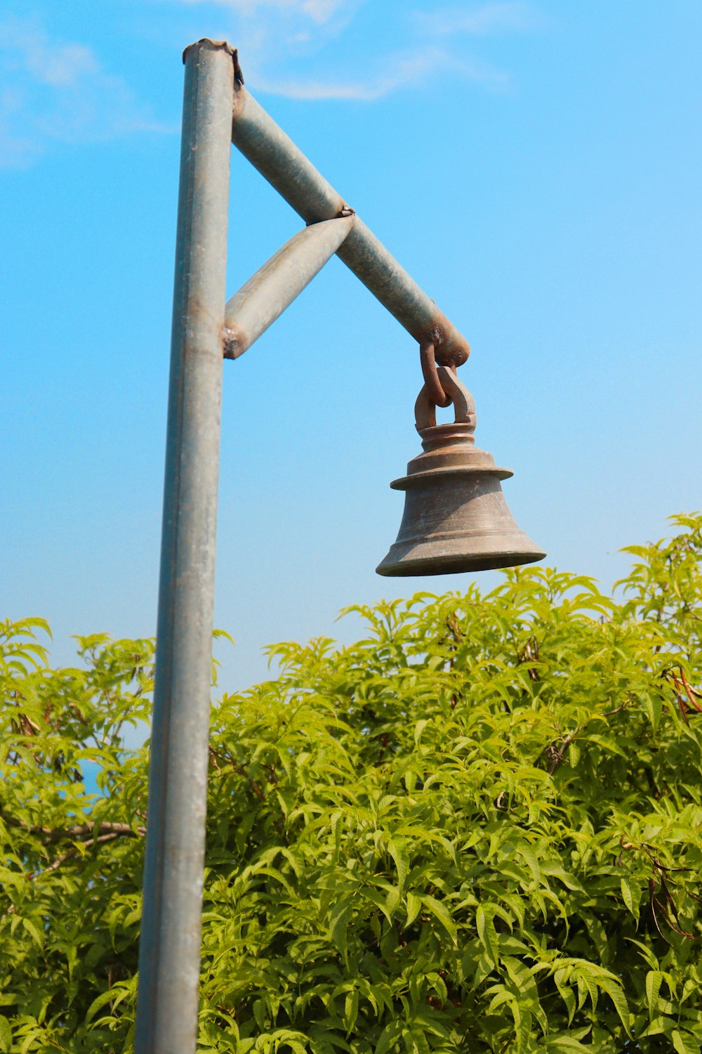 a metal pole with a bell on top of it