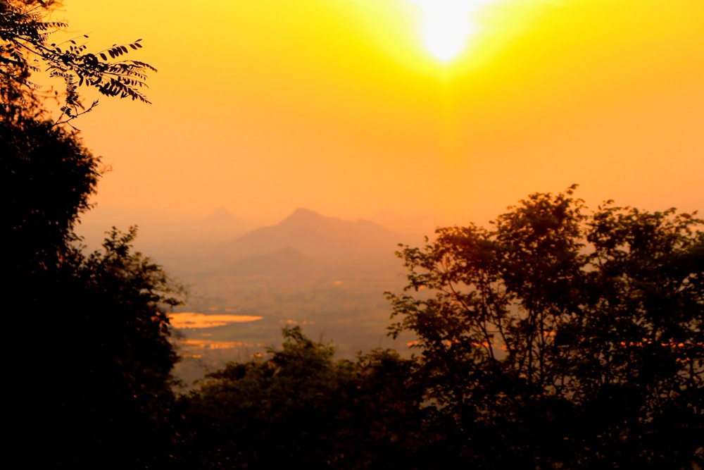 the sun is setting over a mountain range