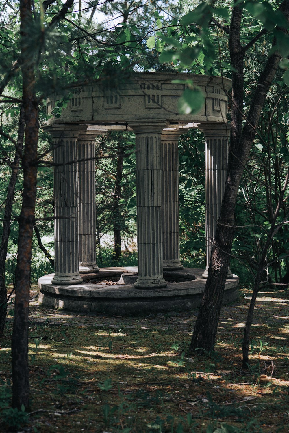 a stone structure in the middle of a forest