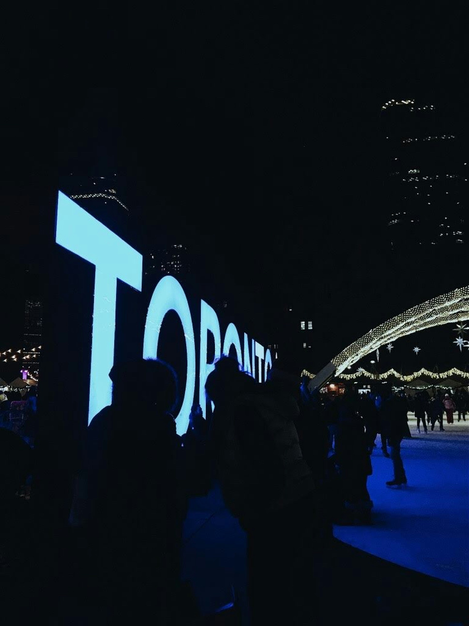 a group of people standing in front of a lighted sign