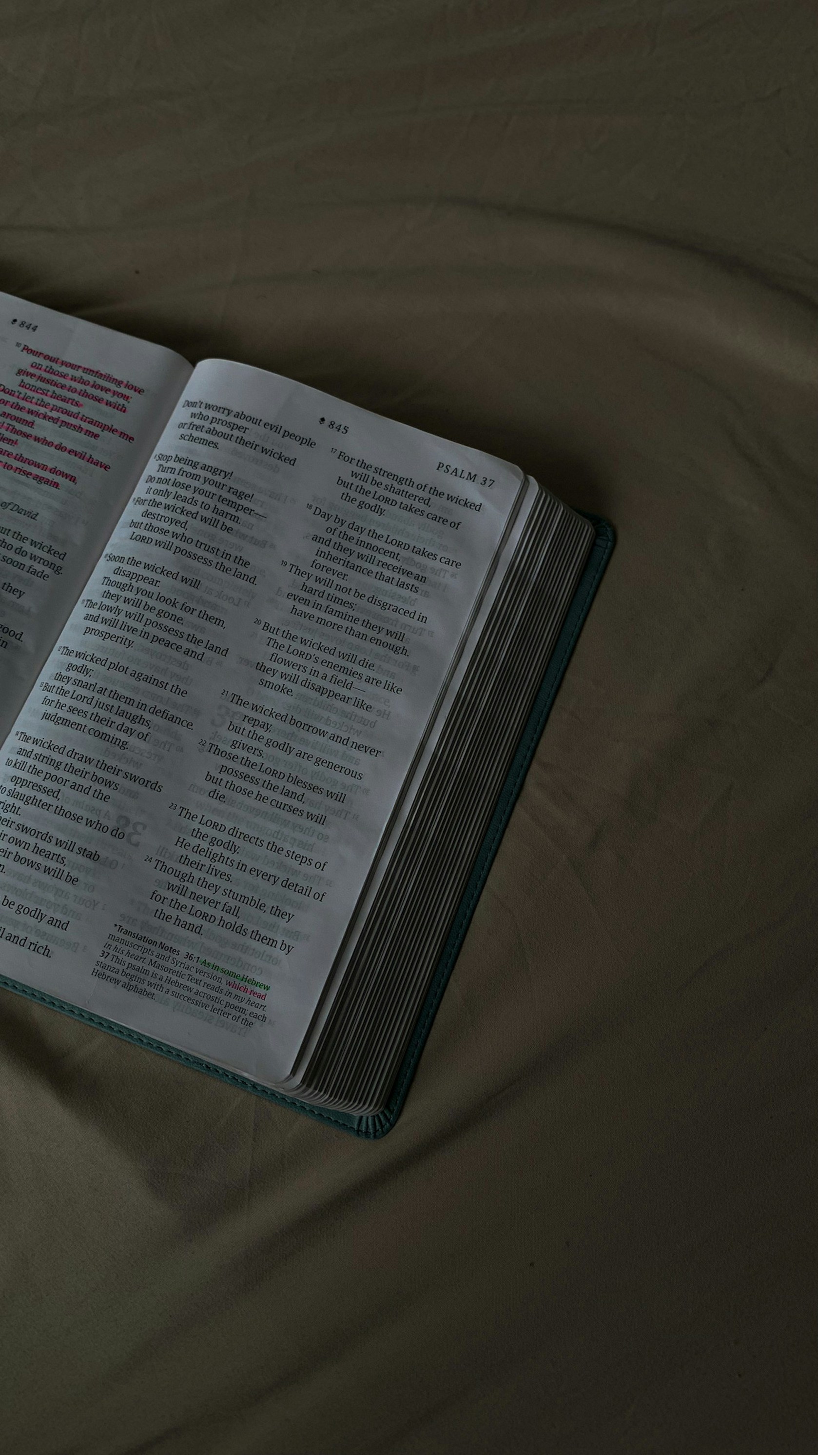 an open book on a bed with sheets