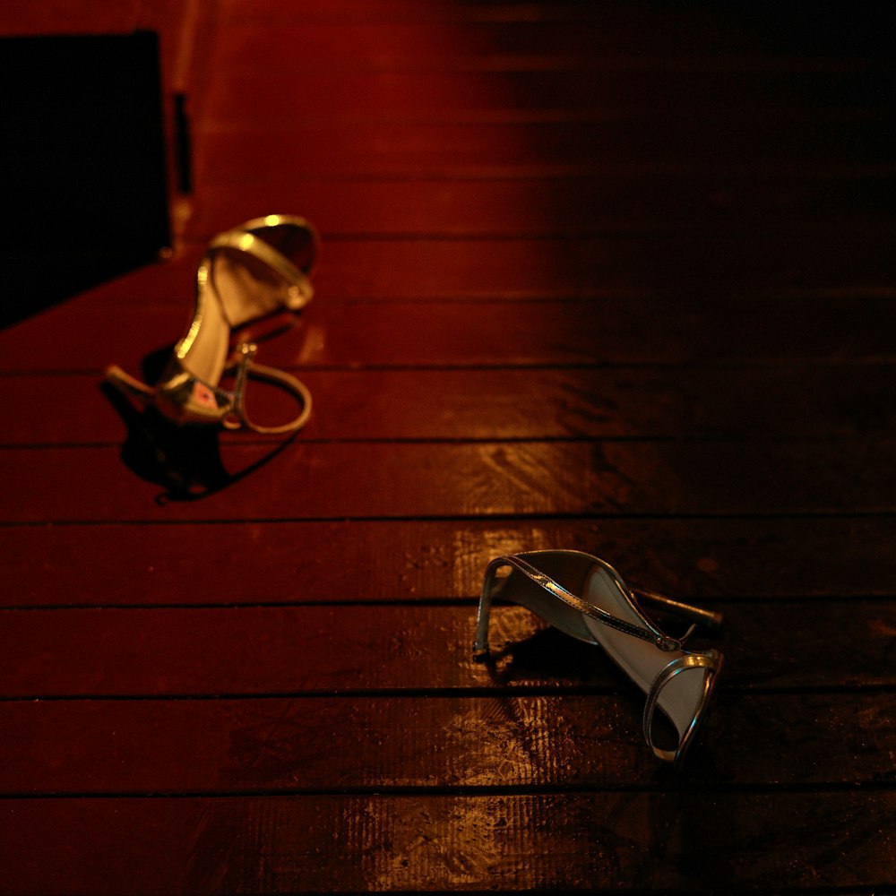 a pair of high heeled shoes sitting on top of a wooden floor