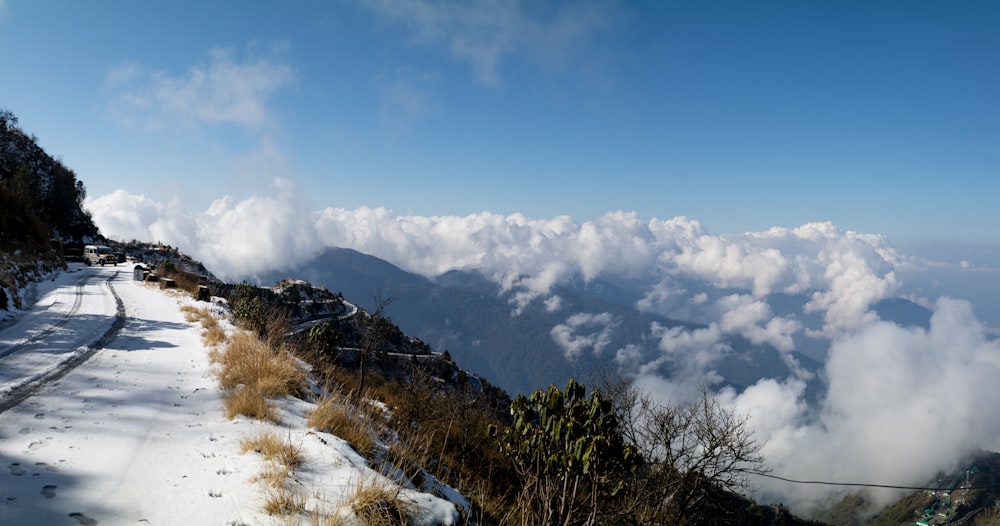 a snow covered mountain side with clouds in the sky