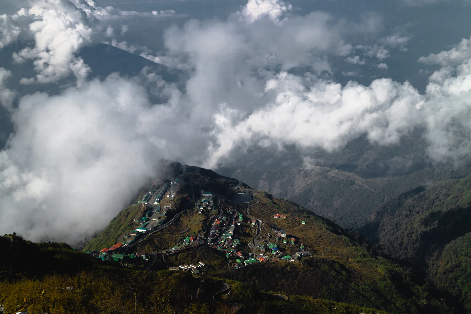 Zuluk's houses and army camp strung along a forested spur in East Sikkim as cloud billows up from the valleys around it