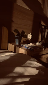 Elegant marble nightstand beside a bed framed with natural jute valances softly lit by morning light.