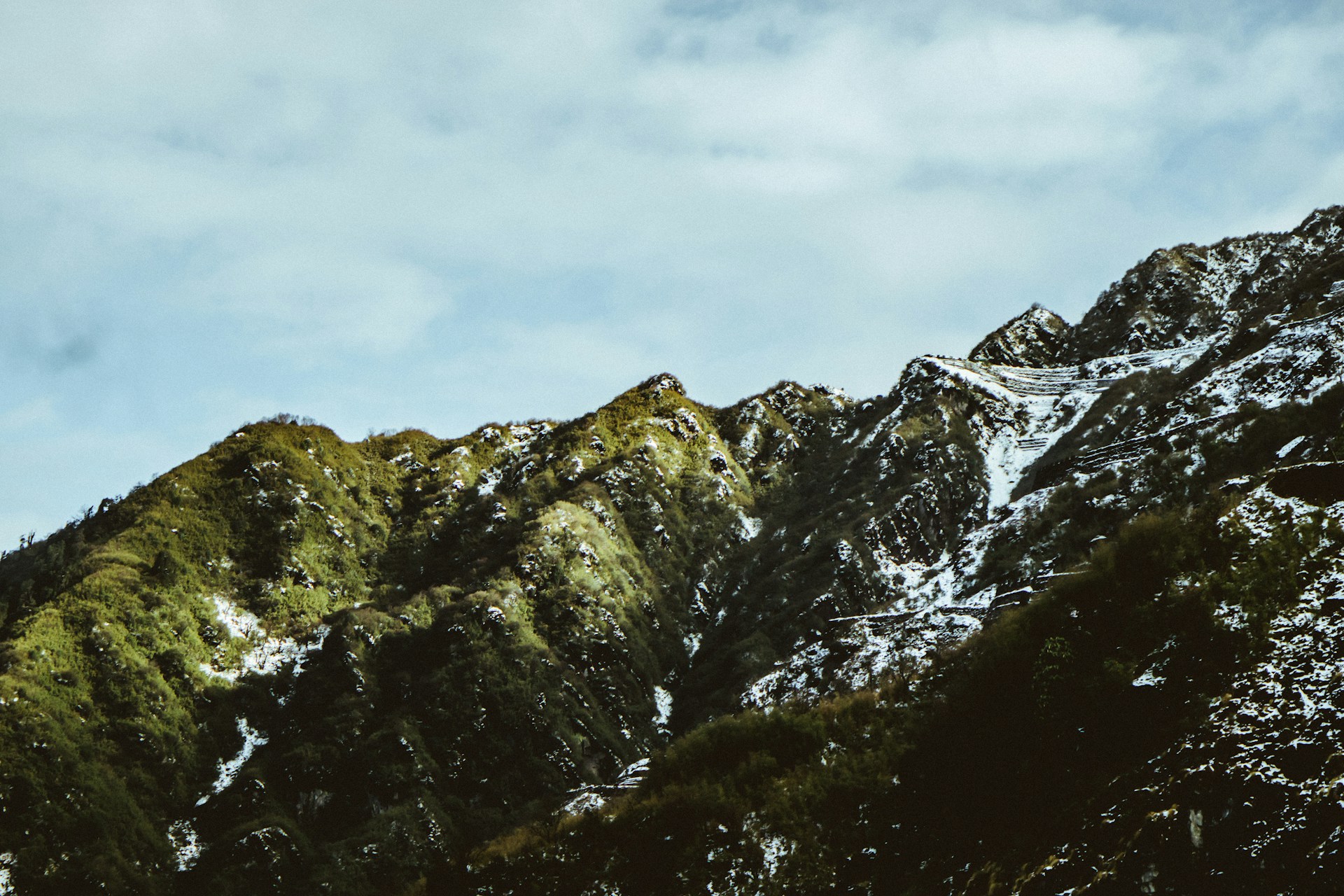 a snowboarder is going down a snowy mountain