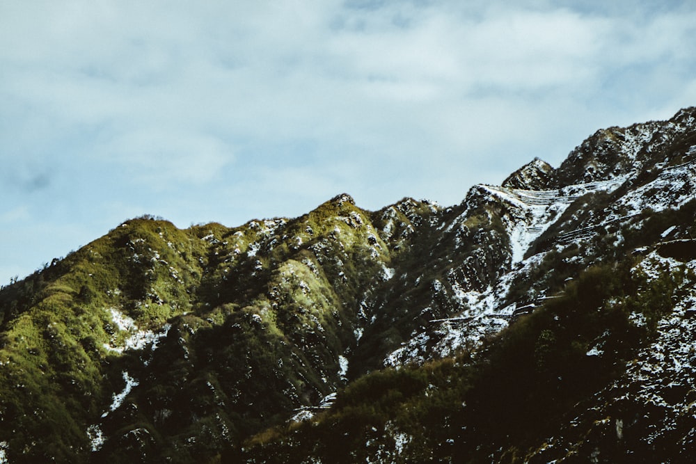 a snowboarder is going down a snowy mountain