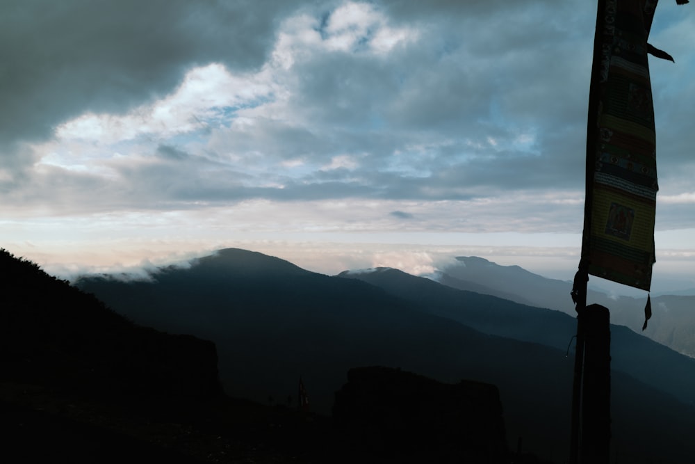 Una bandera en la cima de una montaña bajo un cielo nublado