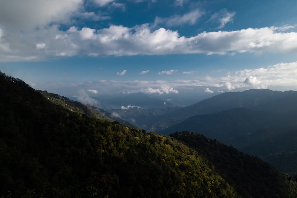 uma vista de uma cordilheira com nuvens no céu