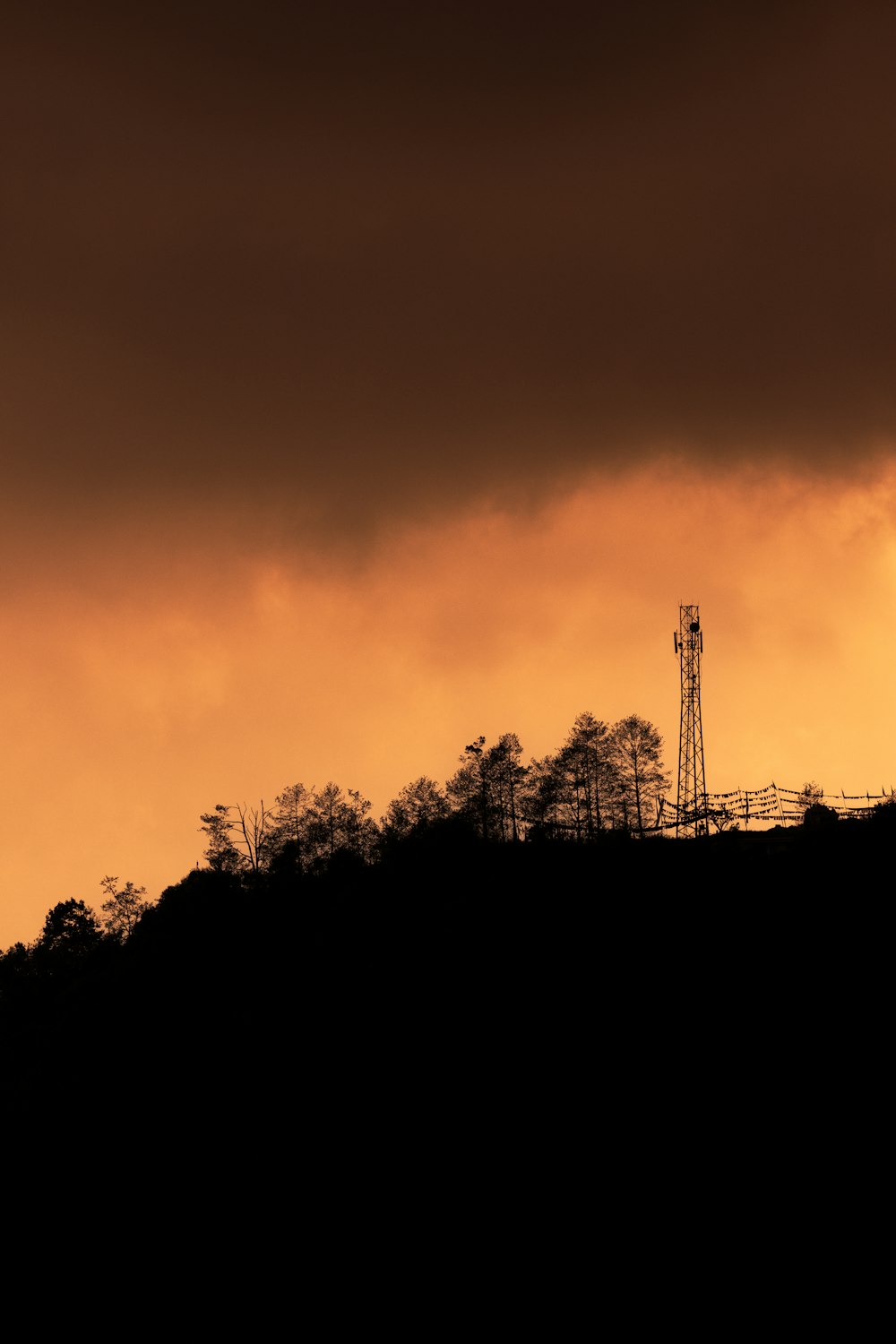 a tower on top of a hill under a cloudy sky